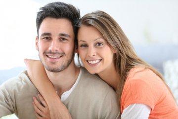 Young couple hugging & smiling l Straighten Teeth Moline IL