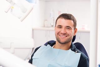 man in dental exam chair smiling I dentist in moline il