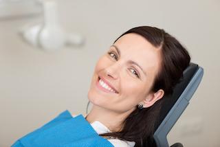 woman laying on dental exam chair smiling I digital dentistry in moline il