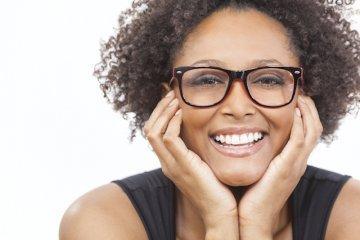 Woman holding her face in her hands smiling l Invisalign Moline IL