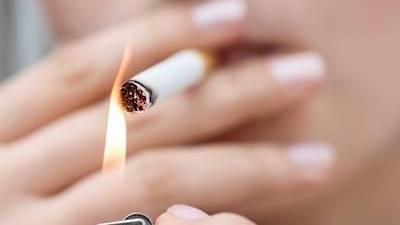 Person smoking cigarette l Dental Implants Moline IL